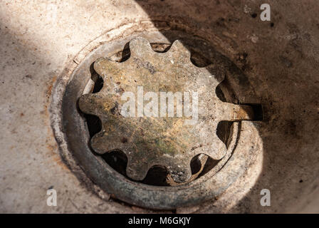 Gusseiserne Ablassloch mit Deckel in einem Waschbecken aus Stein Stockfoto