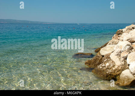 Kristallklares Wasser am felsigen Strand an einem sonnigen Tag Stockfoto