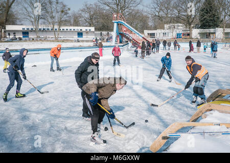 03 März 2018, Deutschland, Hannover: Eishockey Spieler wetteifern um den Puck an der alten Außenpool des Foesse Bad in Limmer. Der Pool war zum Eislaufen und Eishockey überflutet. Foto: Ole Spata/dpa Quelle: dpa Picture alliance/Alamy leben Nachrichten Stockfoto