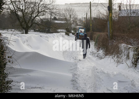 Walker auf einer Landstraße gesperrt durch tiefe Schneeverwehungen. Stockfoto