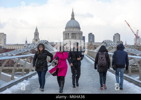 Menschen tragen warme Kleidung gehen über den Millennium (verwackelte) Brücke in der Nähe von St Paul's Cathedral in einem kalten Winter. Stockfoto