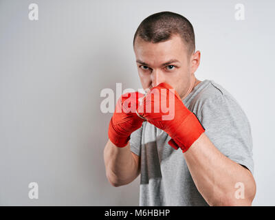 Mann in Rot Boxhandschuhe Bandagen weißer Hintergrund Stockfoto