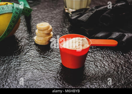 Protein Pulver in Schaufel und Früchte auf steinernen Tisch Stockfoto