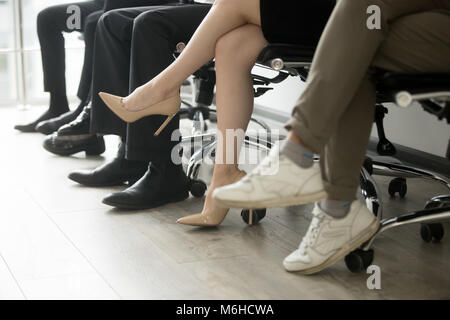 Die Menschen in der Reihe sitzen, Männer und Frauen, die in der Warteschlange warten Stockfoto