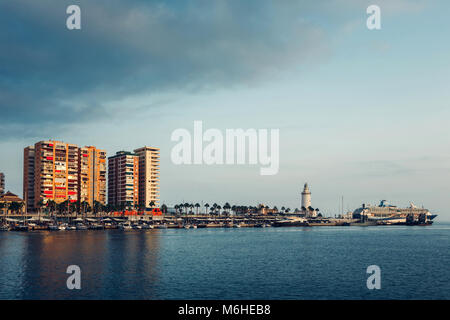 Stadt am Meer - Stadt am Wasser - Stadt Hafen mit Leuchtturm, Cruiser und Wolkenkratzer. Malaga Stadt Port in Spanien Stockfoto