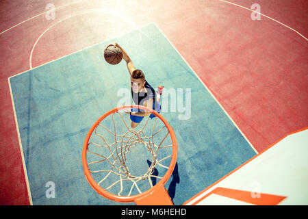 Hohe Betrachtungswinkel der Basketballspieler dunking Basketball in Hoop Stockfoto