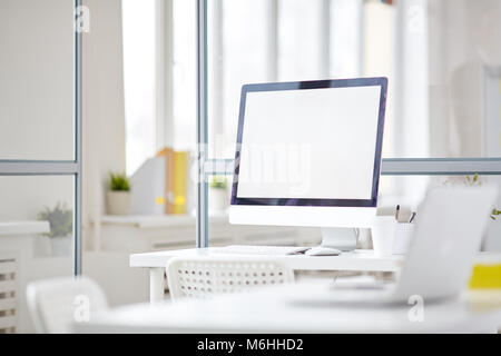 Leeren Büro Raum mit Glas Partitionen und Computer mit leeren Bildschirm auf weißem Schreibtisch Stockfoto