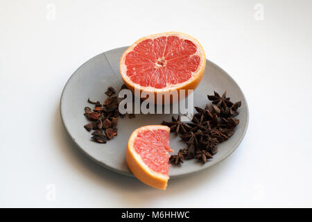 Frische Grapefruit von Schichten und Haufen von Sternanis Arten auf grauem Beton Platte isoliert Stockfoto