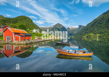 Boote und roten Fischer Hütte, Norwegen, Küste und die Bucht von Balestrand mit Spiegelung der Gletscher in den Bergen, Esefjorden, Sognefjorden Stockfoto