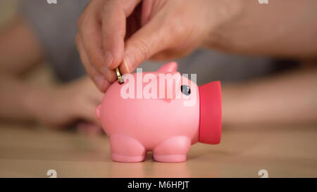 Vater und Kind Geld im Sparschwein für Erwerb, speichern Familie Haushalt Stockfoto