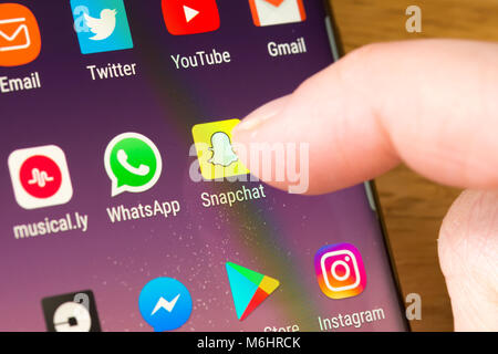 Nahaufnahme der Snapchat App auf einem ausgewählten Smartphone Durch den Finger einer Frau, die auf die App auf dem zeigt Handybildschirm Stockfoto