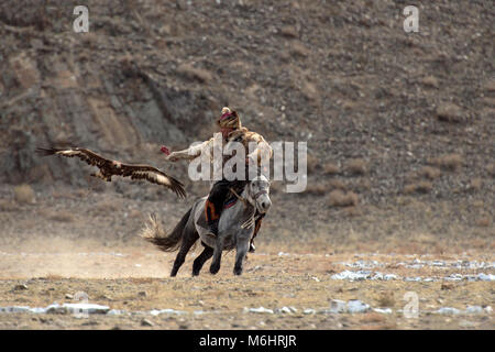 Eine kasachische Eagle Hunter nennt seine Adler während der Golden Eagle festival Wettbewerb 2017 in Olgii, der westlichen Mongolei. Stockfoto