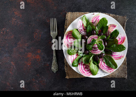 Mit Rüben Salat Platte, von der Wurzel bis zur Blätter, mit einigen Feldsalat und schwarzen Oliven, Overhead shot. Stockfoto