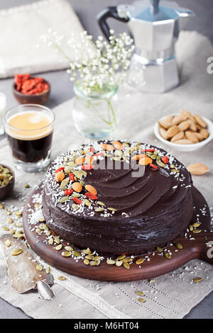 Vegane Schokolade Rüben Kuchen mit Avocado Zuckerguss dekoriert mit Nüssen und Samen. Stockfoto