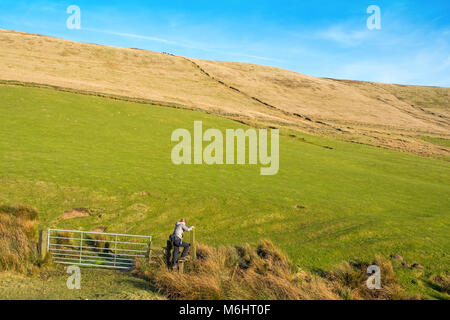 Weibliche Wanderer auf einem Pfad in den Goyt Valley Gegend des Peak District, mit den Katzen Tor/Shining Tor ridge in der Entfernung Stockfoto