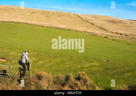 Weibliche Wanderer auf einem Pfad in den Goyt Valley Gegend des Peak District, mit den Katzen Tor/Shining Tor ridge in der Entfernung Stockfoto