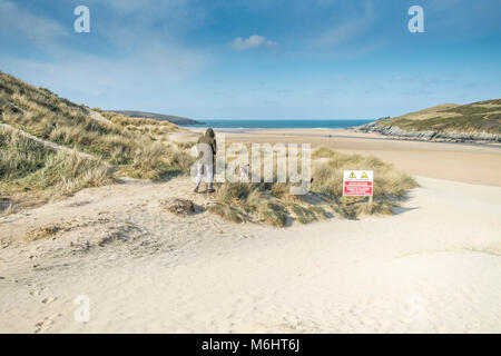 Ein Hund Walker auf Sand Dünen bei Crantock Beach in Newquay Cornwall. Stockfoto