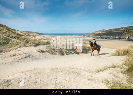 Ein Pferd Reiter auf den Sanddünen bei Crantock Beach in Newquay Cornwall. Stockfoto