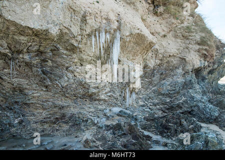 UK Wetter Eiszapfen von Wasser aus dem Grundwasser durch Sanddünen an Crantock Beach in Newquay Cornwall sickert gebildet. Stockfoto