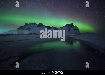 Grünen Reflexionen im Schnee in Stokkness, Island Stockfoto