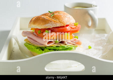 Leckeres Sandwich mit Käse, Schinken und Kaffee Stockfoto