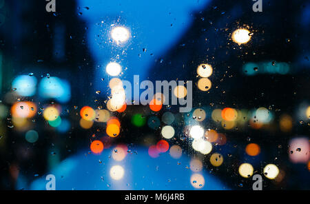 Emotionale romantisch Abstrakt Hintergrund mit Defokussierten Lichter in London bokeh, UK hinter Regen fällt in Fensterglas, konzentrieren sich auf wenige Tropfen aufgrund der geringen Tiefenschärfe Stockfoto