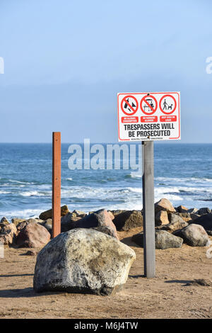 Ein Schild in der Nähe des Strand von Swakopmund Namibia im südlichen Afrika, die Eindringlinge in der frühen Morgensonne am Atlantik genommen verfolgt ein. Stockfoto