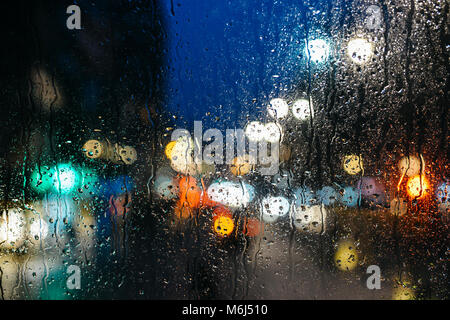 Emotionale romantisch Abstrakt Hintergrund mit Defokussierten Lichter in London bokeh, UK hinter Regen fällt in Fensterglas, konzentrieren sich auf wenige Tropfen aufgrund der geringen Tiefenschärfe Stockfoto