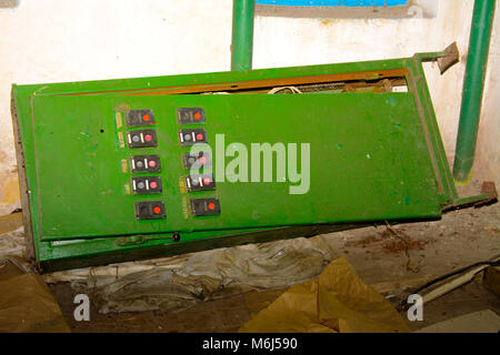 Alte zerlegt und rostige Schalttafel Montage auf einer verlassenen und zerstörten Fabrik vor dem Hintergrund des Chaos. Zerstörung und Vandalismus. Ukrai Stockfoto