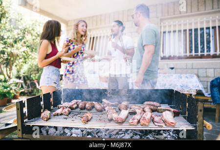 Eine Gruppe von Freunden, Grill im Hof. Konzept über gute und positive Stimmung mit Freunden Stockfoto