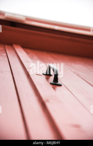 Schwarzer Griff auf der roten Tür Stockfoto
