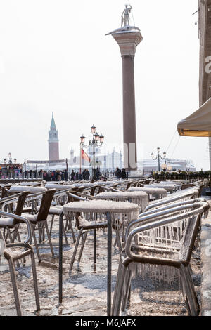 Winter Schnee und Eis, Piazza San Marco, Venedig, Venetien, Italien mit eiszapfen die Beschichtung der Tische und Stühle vor dem Caffe Chioggia während des Sibirischen Stockfoto