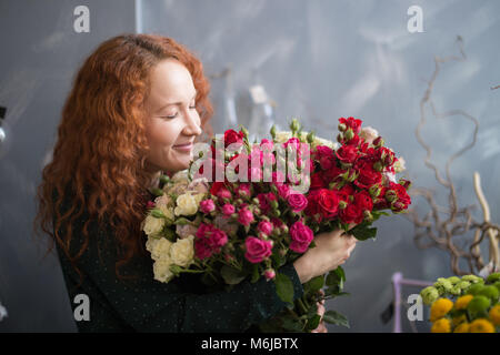 Weibliche florist riechende Blume Blumenstrauß im Blumenladen Stockfoto
