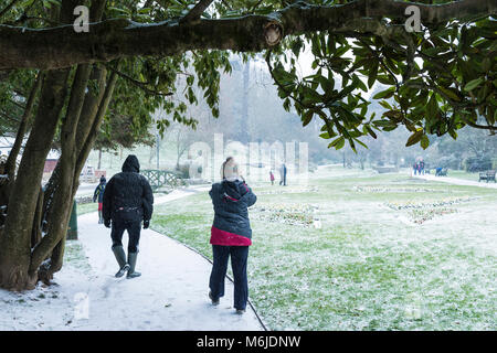 Menschen zu Fuß durch Schnee in Trenance Gärten in Newquay Cornwall. Stockfoto