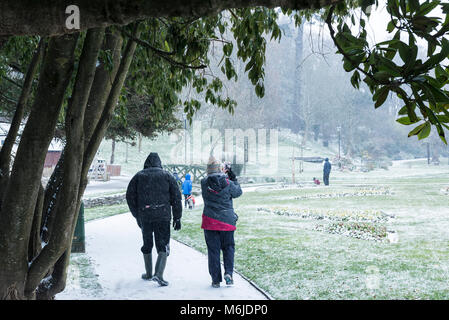 Menschen zu Fuß im Schnee in Trenance Gärten in Newquay Cornwall. Stockfoto