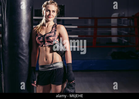 Frau Boxer nach vorne auf einem riesigen Boxsack zu ruhen Stockfoto