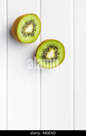 Halbierte Kiwi auf weißer Tisch. Stockfoto