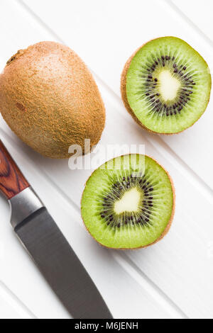 Halbierte Kiwi auf weißer Tisch. Stockfoto