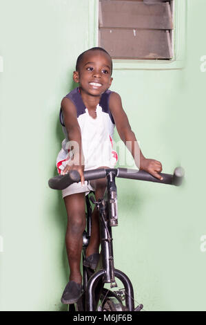 Little Boy tun Fitness Übungen auf dem Fahrrad im Fitnessstudio. Stockfoto