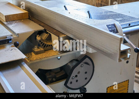 Nahaufnahme der Eichenholzdiele auf der Tischsäge, die die Textur von Holz und Sägeblattzähnen, Holzbearbeitung und Handwerkskunst hervorhebt Stockfoto