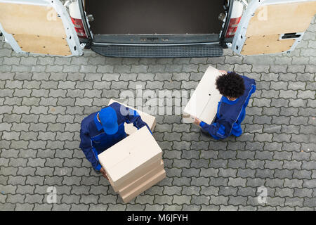 Hohe Betrachtungswinkel und der Lieferung Männer Entladen die Kartons vom Lkw Stockfoto