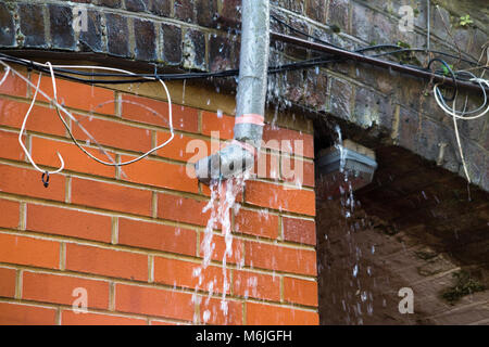 Eine undichte Wasserleitung, die ein Leck in der tauwetterperiode nach in Tagen von Frost mit Schnee und Temperaturen unter Null einfrieren entsprungen ist. UK. Stockfoto