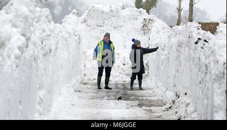 Bruder und Schwester Seamus Ashe und Maureen Sammon Blick in einen Graben von Schnee in Drehungen, Straffan Co. Kildare, als das kalte Wetter weiterhin über dem Land. Stockfoto