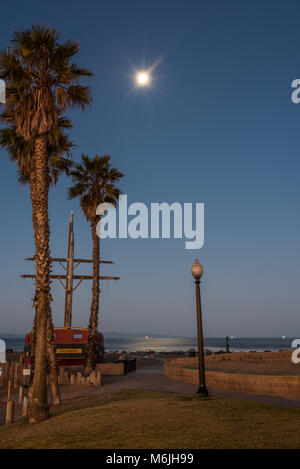 Moonlit morgen leuchtet auf Palmen und Schiffsmasten auf California Beach. Stockfoto