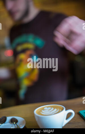 Frisch zubereitete Latte-Art - ein Bild in einer Tasse, das durch Eingießen von geschäumter Milch in Espresso entsteht Stockfoto