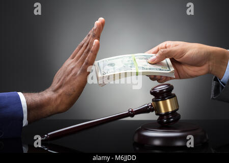 In der Nähe von einem Richter Hand ablehnen, schmiergeld von einem Client gegen grauer Hintergrund Stockfoto