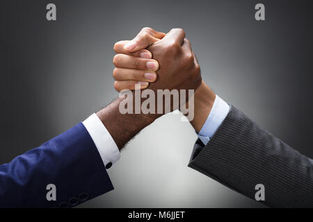 In der Nähe von zwei Unternehmer konkurrieren in den Arm Wrestling auf grauem Hintergrund Stockfoto