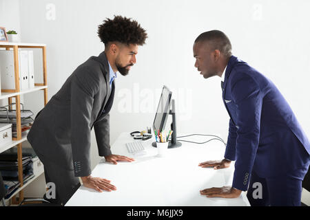 Zwei verärgerte junge Unternehmer bei der Einander am Arbeitsplatz Schreien Stockfoto