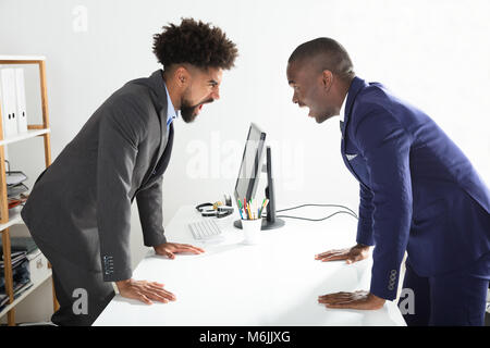 Zwei verärgerte junge Unternehmer bei der Einander am Arbeitsplatz Schreien Stockfoto