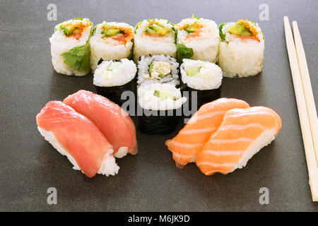 Platte von Sushi rollen. Sushi set Sashimi und Sushi Rollen auf holzteller serviert. Brötchen mit Lachs, Aal, Thunfisch, Avocado, Royal Garnelen, Frischkäse cavia Stockfoto